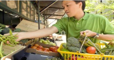 A picture of a boy buying vegetables
